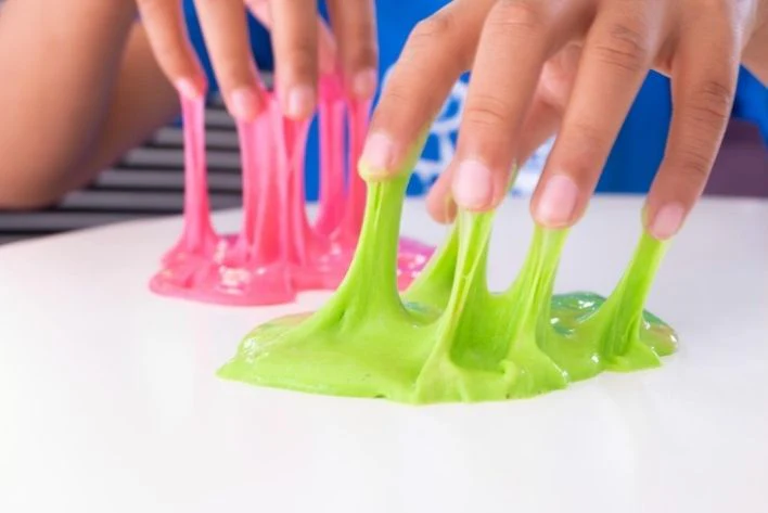 Fingers being pulled out of pink and green slime